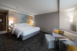 a hotel room with a bed and a couch at Courtyard by Marriott Russellville in Russellville