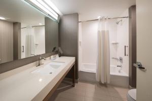 a bathroom with two sinks and a tub and a shower at Courtyard by Marriott Russellville in Russellville