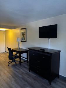 a hotel room with a desk and a television at Inn On The Green Florida in Tavares
