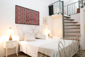 a bedroom with a white bed and a staircase at Elamar Apartments in Gallipoli