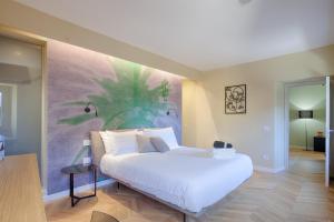 a bedroom with a white bed with a painting on the wall at 1029 GuestHouse in Sora