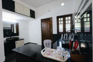 a kitchen with a black counter top in a room at Aroha luxury homestay in Madikeri