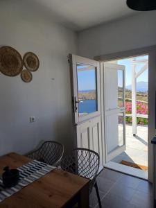a dining room with a table and chairs and a door at Romantic House Sea View Adults only in Ios Chora