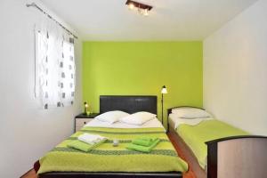 a bedroom with two beds with lime green walls at Three bedded room with an outdoor kitchen in Stari Grad
