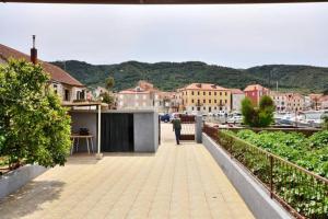 a person standing on a balcony of a building at Three bedded room with an outdoor kitchen in Stari Grad