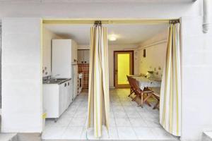a kitchen with yellow curtains in a kitchen with a table at Three bedded room with an outdoor kitchen in Stari Grad