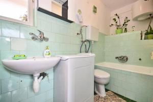 a bathroom with a sink and a toilet at Three bedded room with an outdoor kitchen in Stari Grad