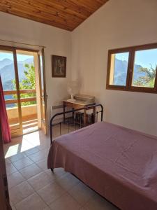 a bedroom with a bed and a table and a desk at MAISON TUCCARELLU in Letia
