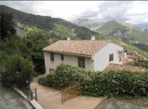 a white house with mountains in the background at MAISON TUCCARELLU in Letia