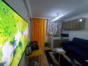 a living room with a tv and a blue couch at Velour Spacious Suites in Rungiri