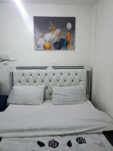 a bedroom with a white bed with a headboard at Velour Spacious Suites in Rungiri