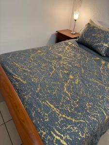 a bedroom with a bed with a blue and gold blanket at Apparemment 2 pièces in Vaulx-en-Velin