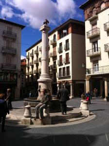 un grupo de personas sentadas alrededor de una fuente en una ciudad en Duplex Torico Amantes, en Teruel