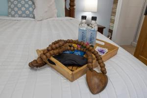 a set of two bottles of water and a wooden necklace on a bed at Honeymoon Suite with Shared POOL in Bay Saint Louis