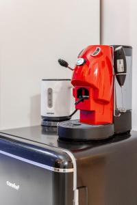 a red sewing machine sitting on top of a appliance at Nalusa - al centro della riviera di chiaia in Naples +6 photos