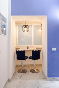 a kitchen with two chairs and a table at Nalusa - al centro della riviera di chiaia in Naples
