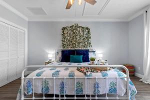 a bedroom with a bed with a blue and white comforter at Suite Flamingo Pointe with Shared POOL in Bay Saint Louis