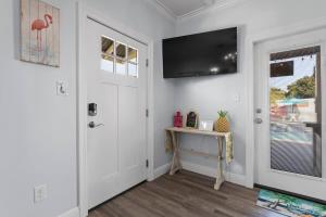 a white hallway with a door and a table and a window at Suite Flamingo Pointe with Shared POOL in Bay Saint Louis +22 photos