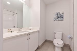 a white bathroom with a toilet and a sink at Private Apt Downtown in Quincy