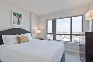 a bedroom with a white bed with a large window at Private Apt Downtown in Quincy