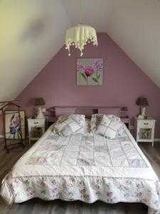 a bedroom with a bed with a purple wall at Murmure de Tilleul in Alembon