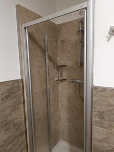 a shower with a glass door in a bathroom at Alexander Lodge in Isolaccia +17 photos
