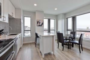 a kitchen with a table and chairs and windows at Spacious Apt Downtown in Quincy