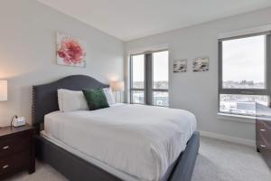 a bedroom with a large bed and two windows at Spacious Apt Downtown in Quincy