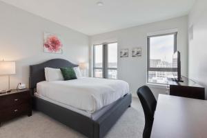 a bedroom with a bed and a desk and windows at Spacious Apt Downtown in Quincy