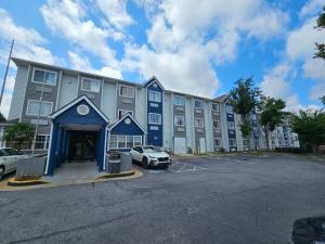 a large building with a car parked in a parking lot at Microtel Inn by Wyndham Atlanta Airport in Atlanta
