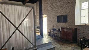 a living room with a sliding glass door and a desk at Keresbino Hydra Manor House in Hydra