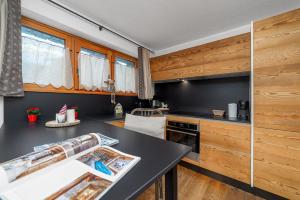 a kitchen with a black counter top and wooden cabinets at Maison Carrel Elegant 8 in Breuil-Cervinia