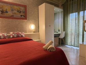 a bedroom with a red bed with a towel on it at Hotel Picador in Rimini +29 photos