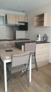 a kitchen with a table and chairs in a kitchen at le pied des monts in Sainte-Consorce