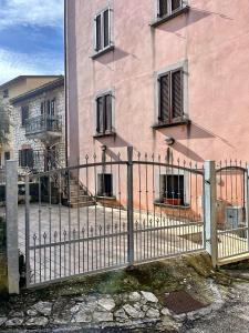 a fence in front of a building with windows at Casa dei nonni in Rigali