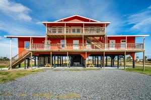 a large red house with a balcony and stairs at 6 Bedroom, 3 unit Triplex in Crystal Beach in Port Bolivar