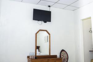 a mirror and a tv on a wall at Hotel Pablo Tesák in San Vicente