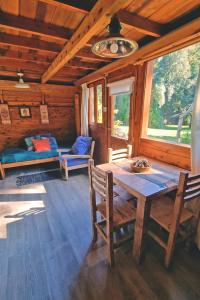 a dining room with a table and a couch in a cabin at Complejo Aiken in Villa Traful