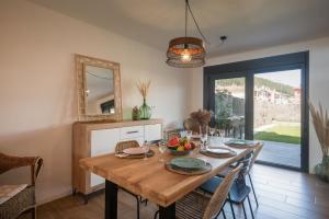 a dining room with a wooden table and a mirror at Ribadesella Casa con Jardín a 2 km Playa – Saelia in Ribadesella