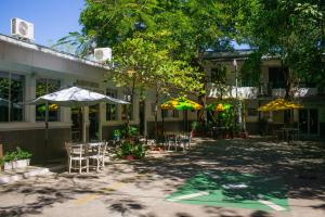 a patio with chairs and umbrellas in front of a building at Hotel Pablo Tesák in San Vicente