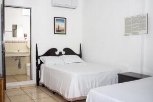 a bedroom with a bed and a bathroom with a sink at Hotel Pablo Tesák in San Vicente +47 photos