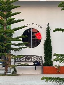 a bench in front of a building with a tree at เพลินวิวโขงรีสอร์ท Plearnviewkhongresort in Ban Nong Mum