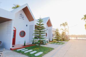 a white building with trees in front of it at เพลินวิวโขงรีสอร์ท Plearnviewkhongresort in Ban Nong Mum