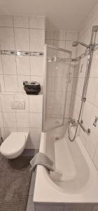 a white bathroom with a shower and a toilet at Boxspring Apartment Rottweil mit Stellplatz in Rottweil
