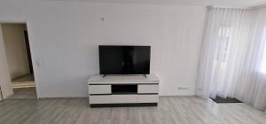 a flat screen tv sitting on top of a white cabinet at Boxspring Apartment Rottweil mit Stellplatz in Rottweil