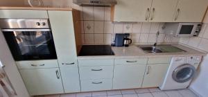 a small kitchen with a sink and a microwave at Boxspring Apartment Rottweil mit Stellplatz in Rottweil +10 photos