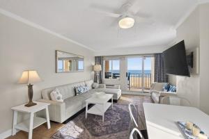 a living room with a couch and a table at New / Oceanfront Beach Condo, Pool, Gym, Fishing in Virginia Beach