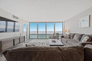 a living room with a couch and a table at Oceanfront Condo/ Pool/ Surfing/ Fishing / EW 1002 in Virginia Beach +33 photos