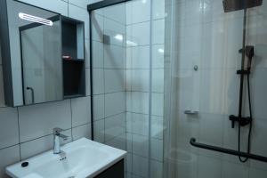 a bathroom with a sink and a glass shower at Kaze Consolidate Home Inn in Kigali +29 photos