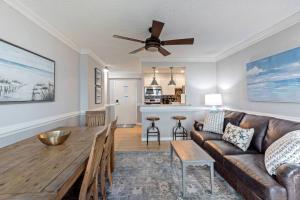 a living room with a couch and a table at Oceanfront Condo, Heated Pool, Fitness Center in Virginia Beach